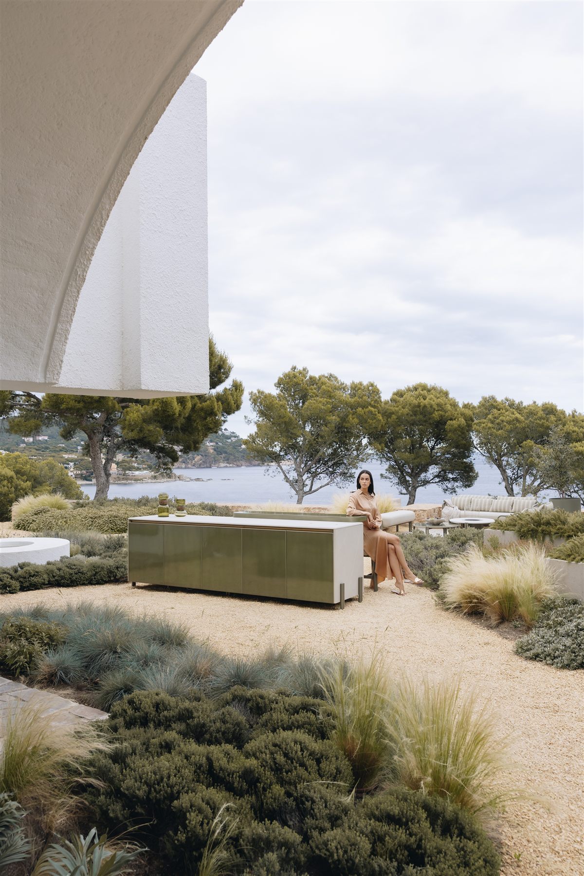 LAVA outdoor kitchen framed by white arched architecture with the sea beyond